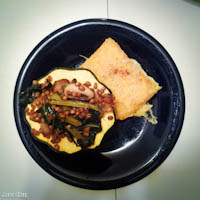 Acorn squash stuffed with wheat berries, mushrooms, and collard greens; grilled polenta cake with spicy sweet potato puree and cheddar cheese